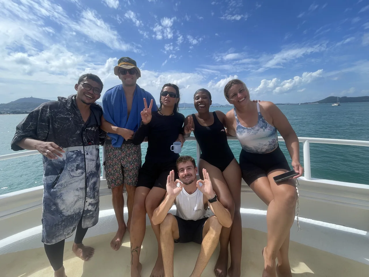 Students and an instructor together on a boat with the sea behind them