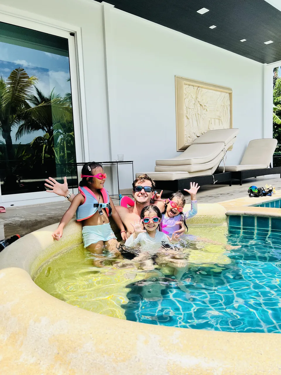 Children and an instructor smiling together in a swimming pool