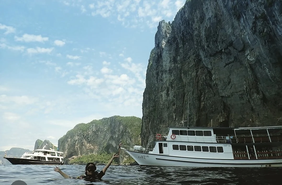 Dive boats beneath island cliffs